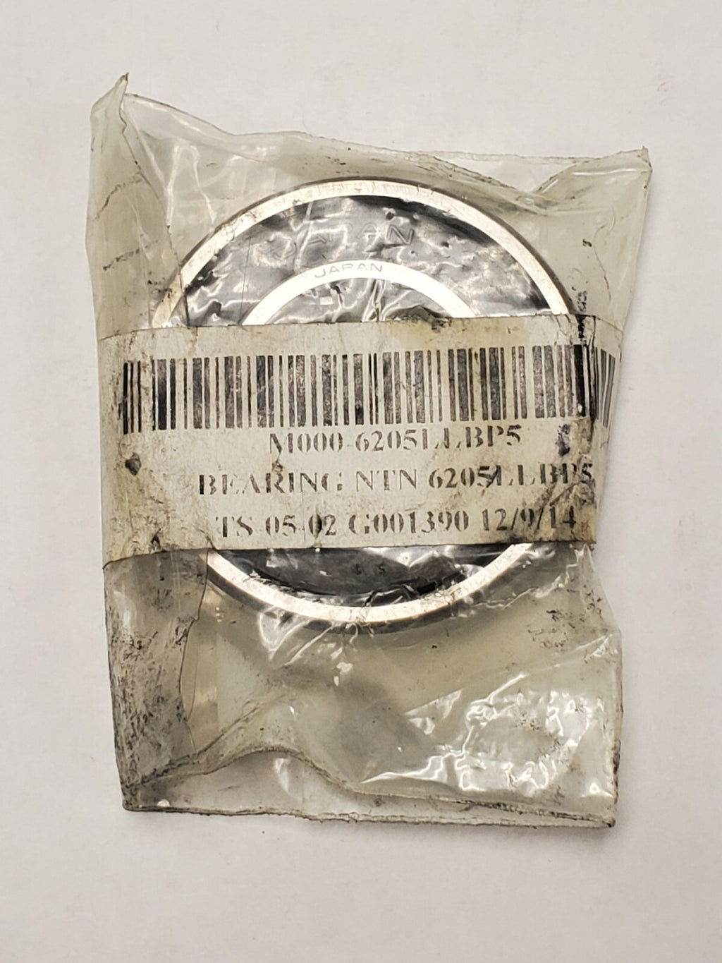 Metal bearing in clear plastic packaging with a barcode label on a white background