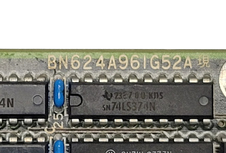Close-up of electronic components with visible serial numbers on a printed circuit board.