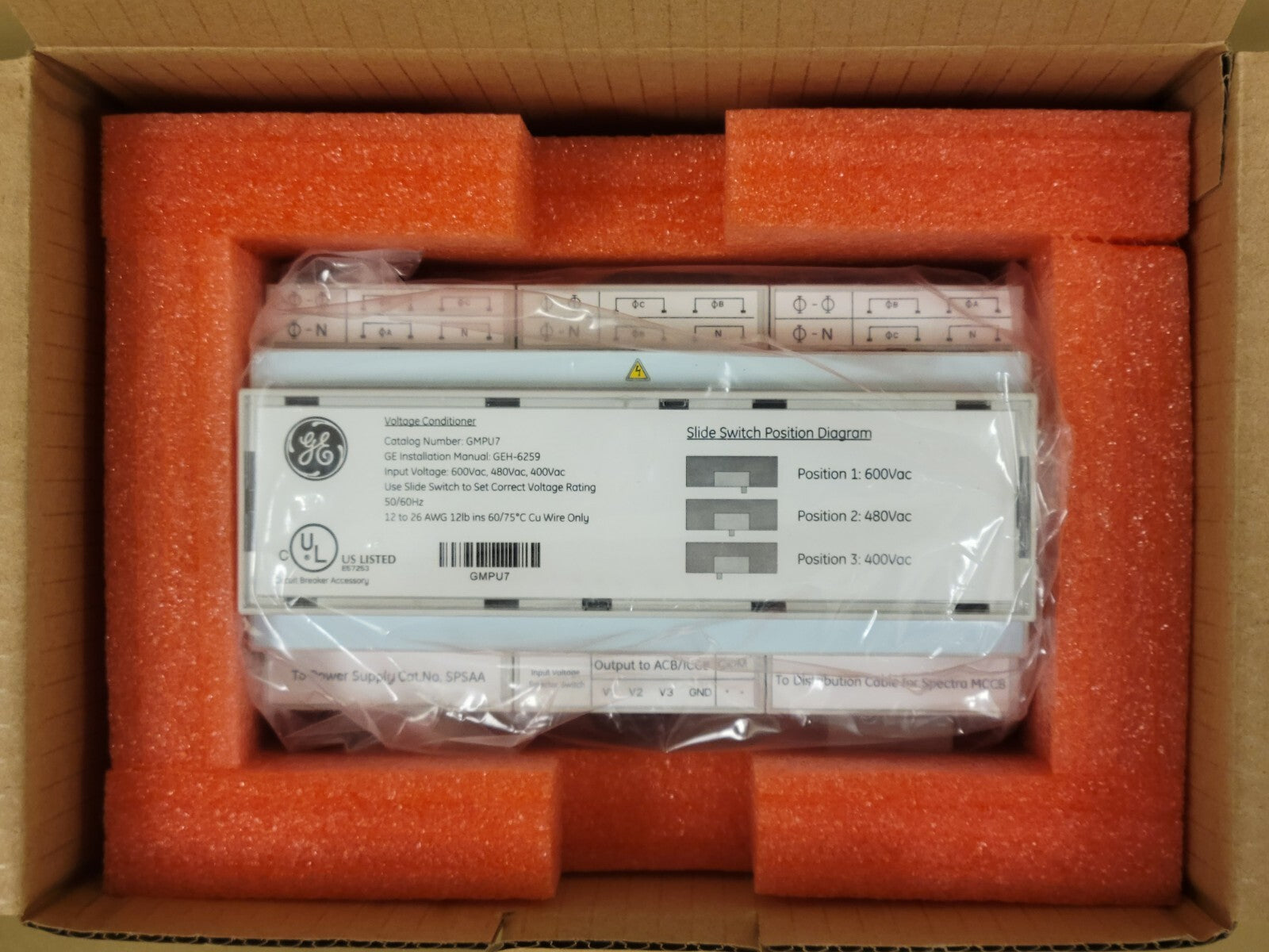 Electrical panel with GE label inside an open cardboard box with orange foam padding.